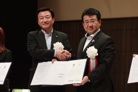 調印した協定書を手にする広瀬市長と大西高松市長の写真