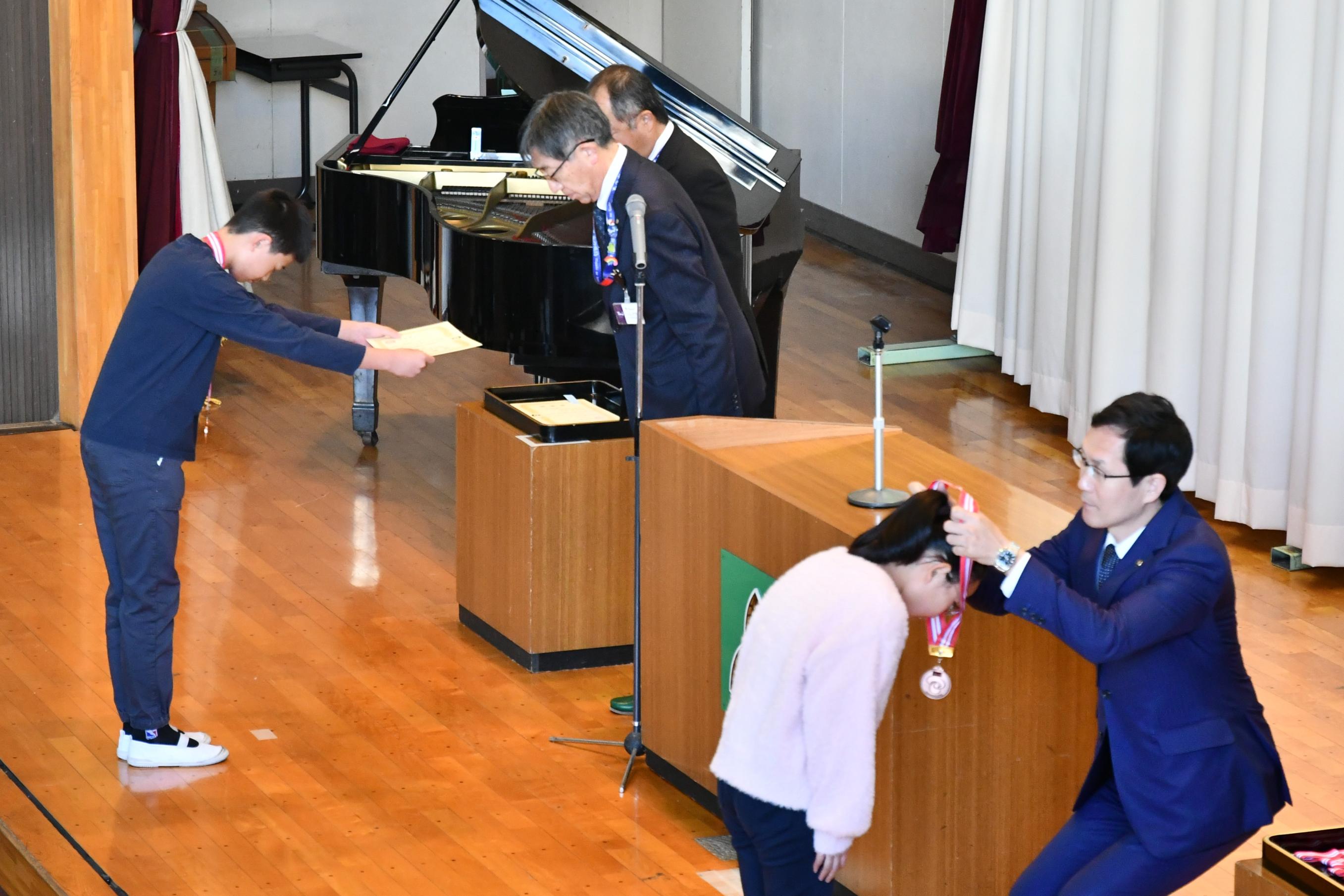 賞状とメダルを授与される児童の様子2