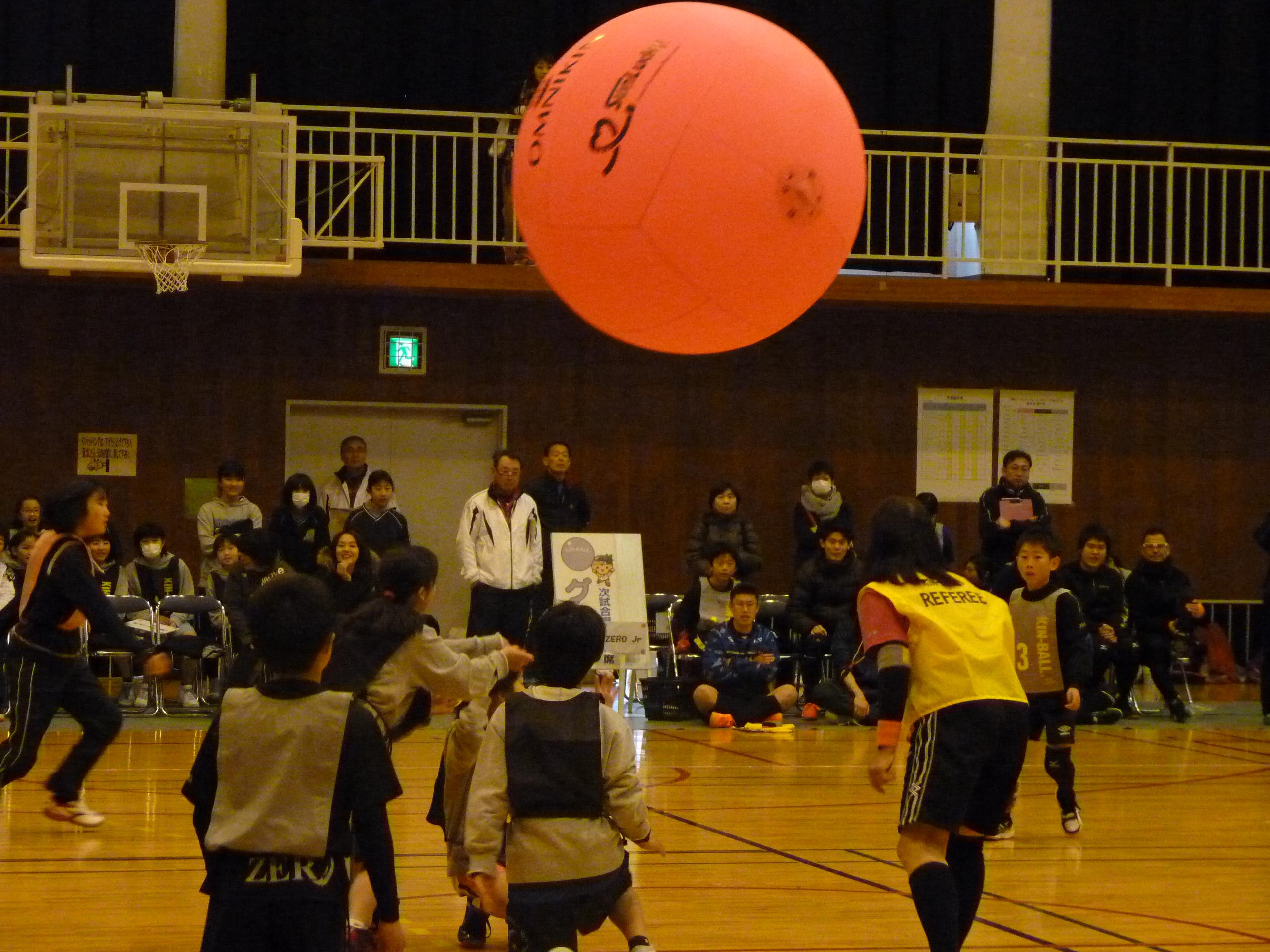 大きなピンクのボールが宙を舞う  キンボールスポーツを行う様子