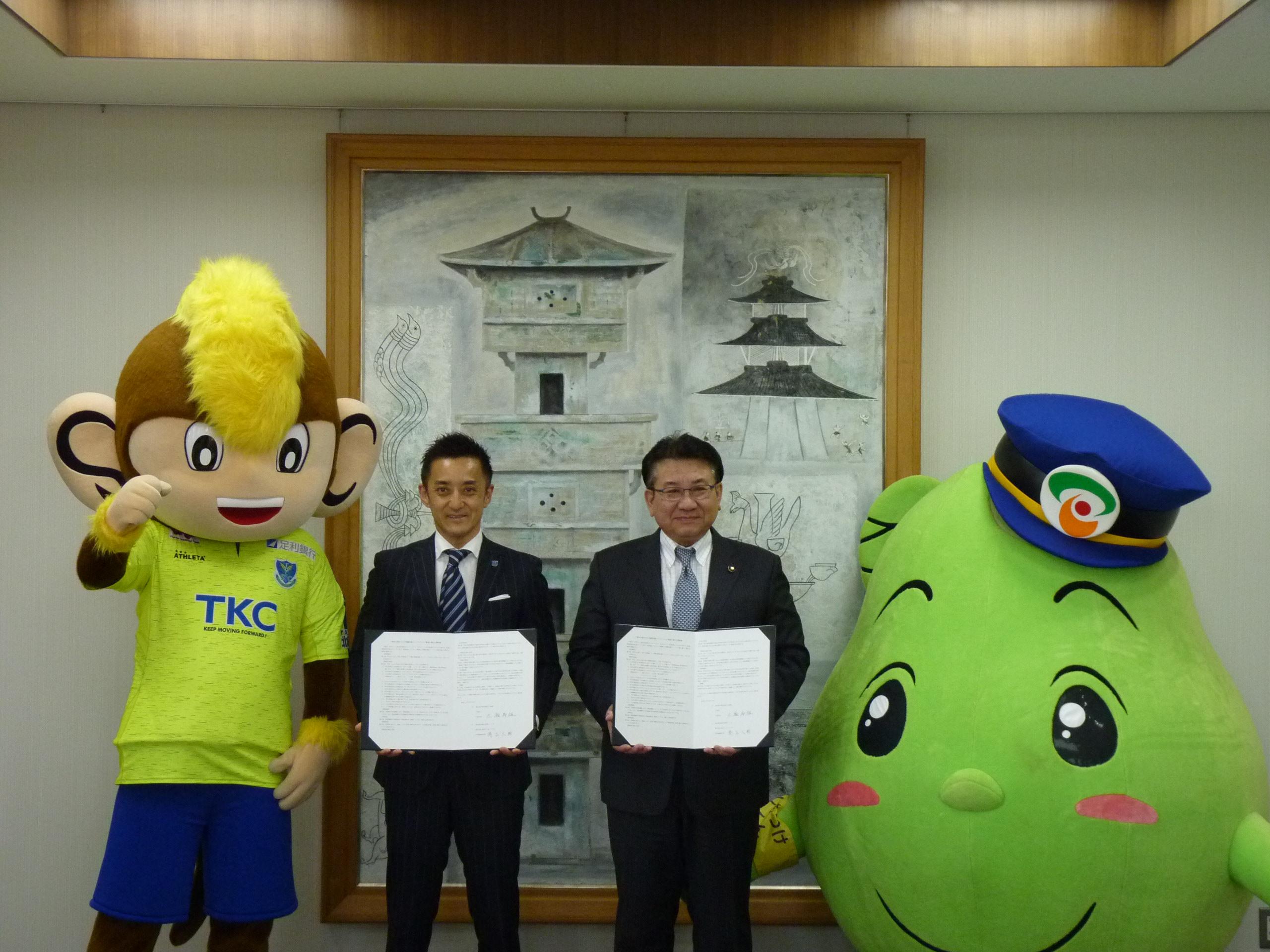 協定書を手にする栃木SC代表と市長