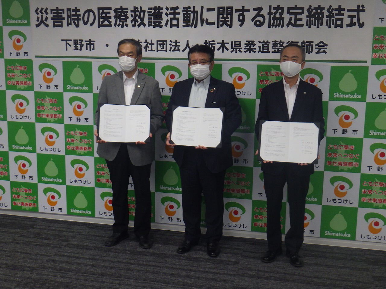 協定書を手にする栃木県柔道整復師会の方々と市長