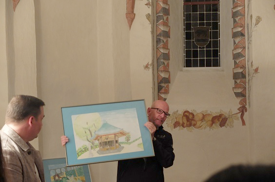 国際交流図画コンクールの入賞作品を掲げるトーマス市長