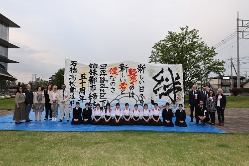 完成した作品を囲む姉妹都市訪問団と石橋高校 書道部員
